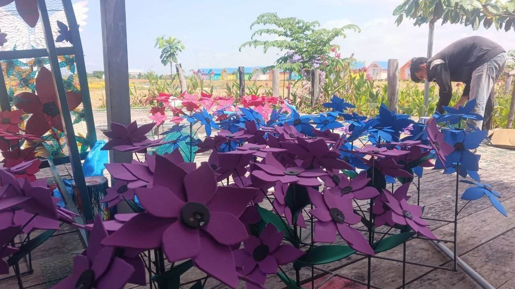 Vibrant painted upcycled rubber flowers drying in the sun.