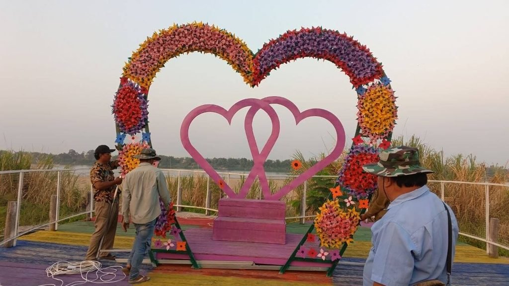 Workers assembling the colorful Couple's Heart Arch photo installation at Dream Garden.