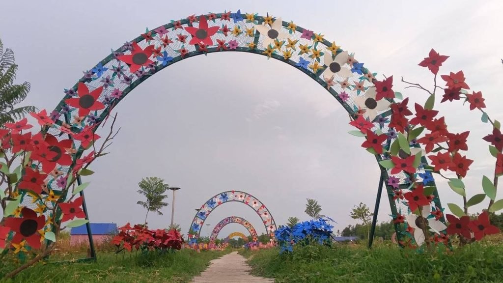 DIY garden archway made from steel pipe and crafted rubber flowers.