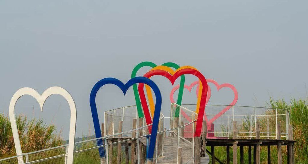 The Rainbow Heaven Bridge featuring multi-colored heart arches on a raised wooden walkway.